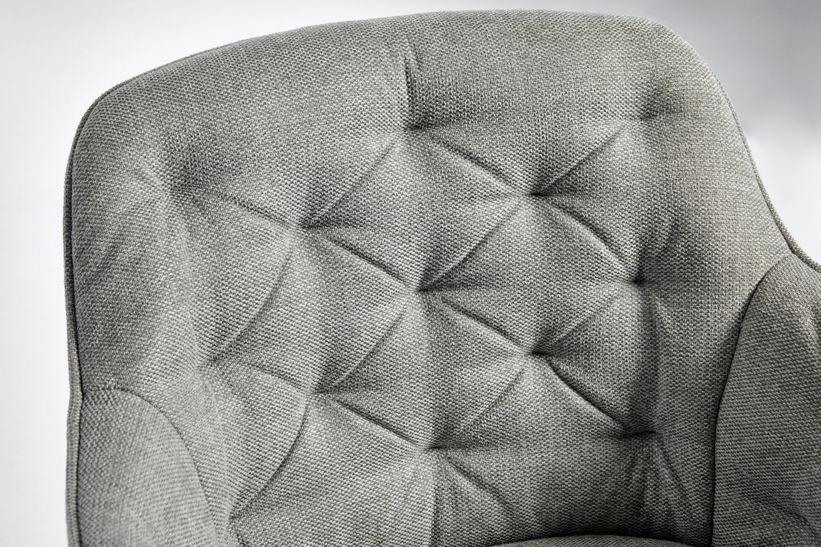 Grauer, gepolsterter Stuhl mit gestepptem Design, Nahaufnahme der Rückenlehne