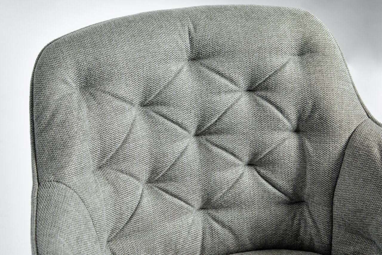 Grauer, gepolsterter Stuhl mit gestepptem Design, Nahaufnahme der Rückenlehne