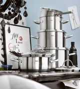 Topfset Paris 5-tlg. aus Edelstahl, seitliche Perspektive, gestapelt auf einem Tisch mit dekorativem Hintergrund.