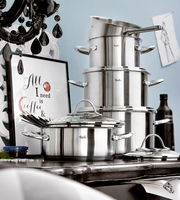 Topfset Paris 5-tlg. aus Edelstahl, seitliche Perspektive, gestapelt auf einem Tisch mit dekorativem Hintergrund.