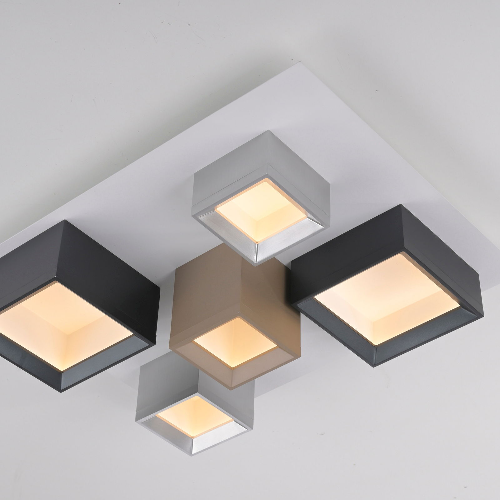 Moderne LED-Deckenleuchte mit vier quadratischen Leuchtelementen in verschiedenen Farben, aus der Vogelperspektive fotografiert.