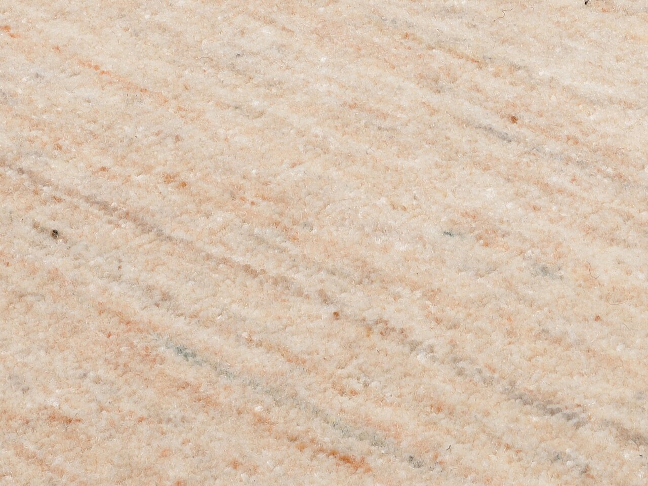 Nahaufnahme eines Wollteppichs mit beiger und leicht gemusterter Textur.