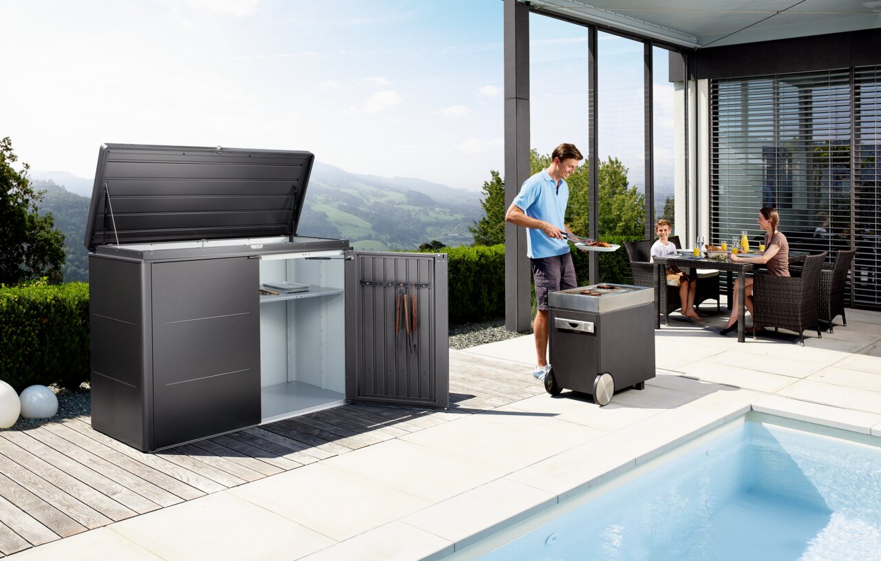 Hochwertiges Highboard im modernen Design, geöffnet gezeigt auf einer Terrasse mit Blick auf die Berge. Perfekt für stilvolle Aufbewahrung im Außenbereich.