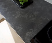 Draufsicht auf eine dunkle Küchenarbeitsplatte mit Kräutern auf einem Tablett.