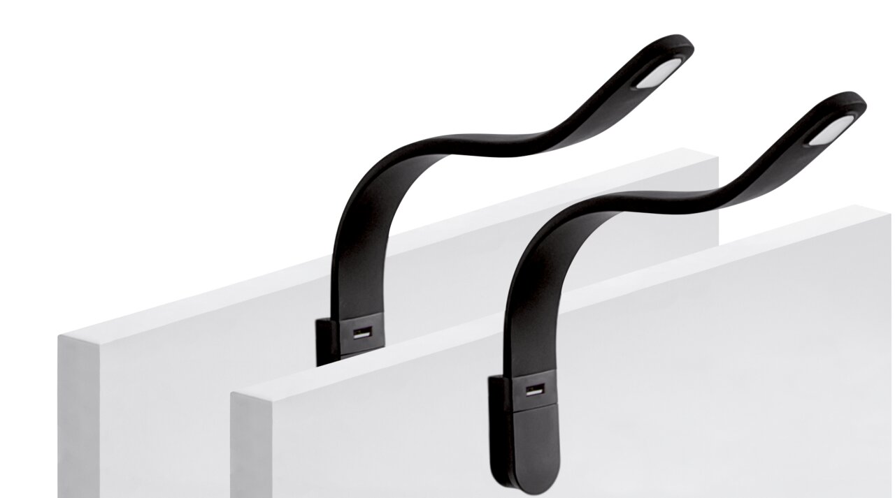 Zwei flexible, schwarze Leseleuchten Silka, die an weißen Oberflächen befestigt sind, seitliche Perspektive.
