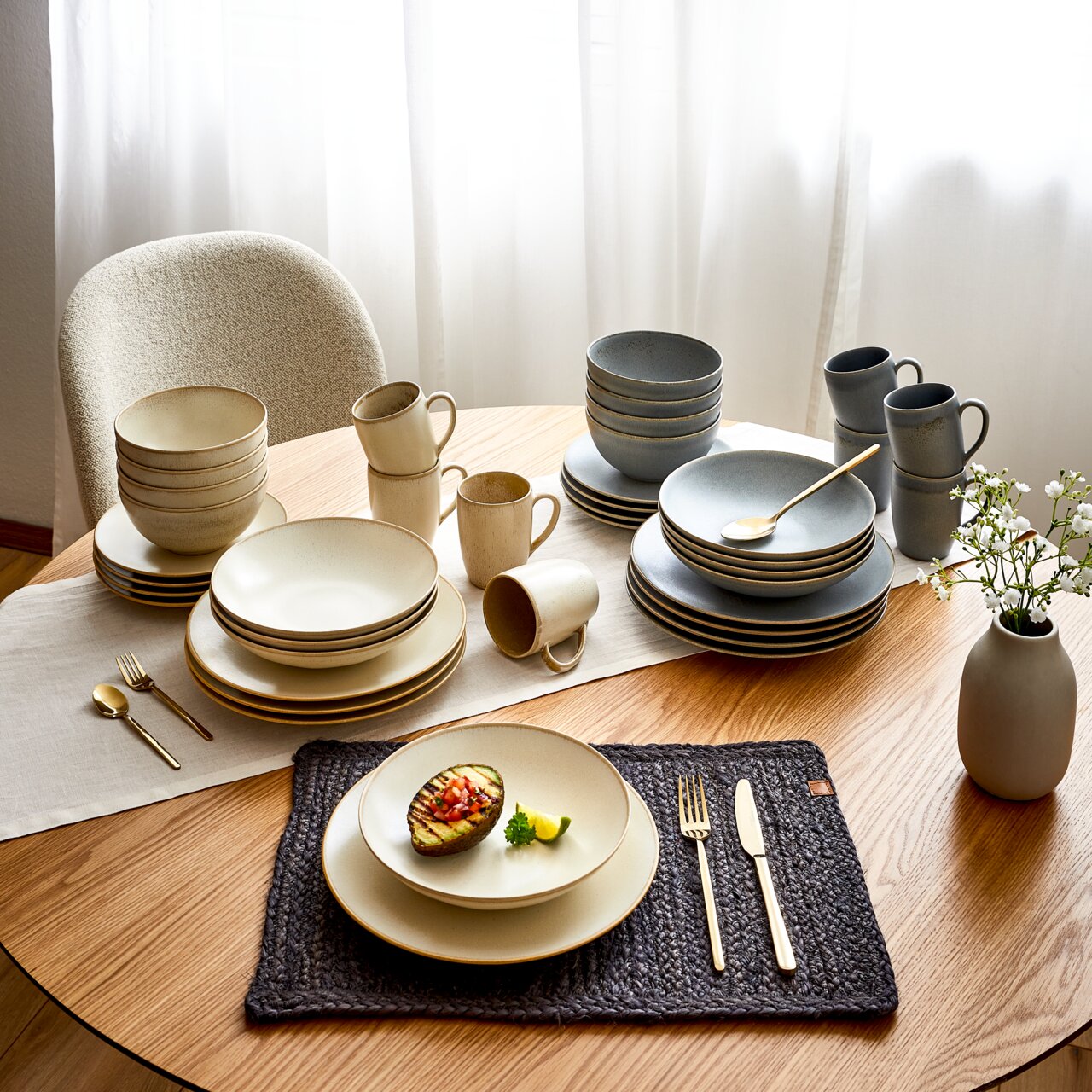 20-delige servieset Cafe del op een gedekte tafel, bestaande uit borden, schalen en kopjes in neutrale kleuren, met goudkleurig bestek en een decoratieve vaas. Aanzicht van bovenaf.