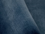 Nahaufnahme eines blauen Teppichs mit weicher Textur, perspektivisch von der Seite aufgenommen.