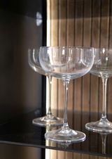 Nahaufnahme von eleganten Weingläsern in einem Highboard, seitliche Perspektive