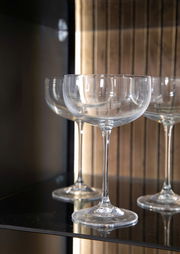 Nahaufnahme von eleganten Weingläsern in einem Highboard, seitliche Perspektive