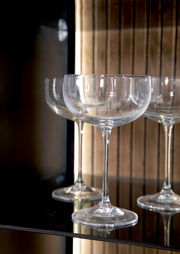 Nahaufnahme von eleganten Weingläsern in einem Highboard, seitliche Perspektive