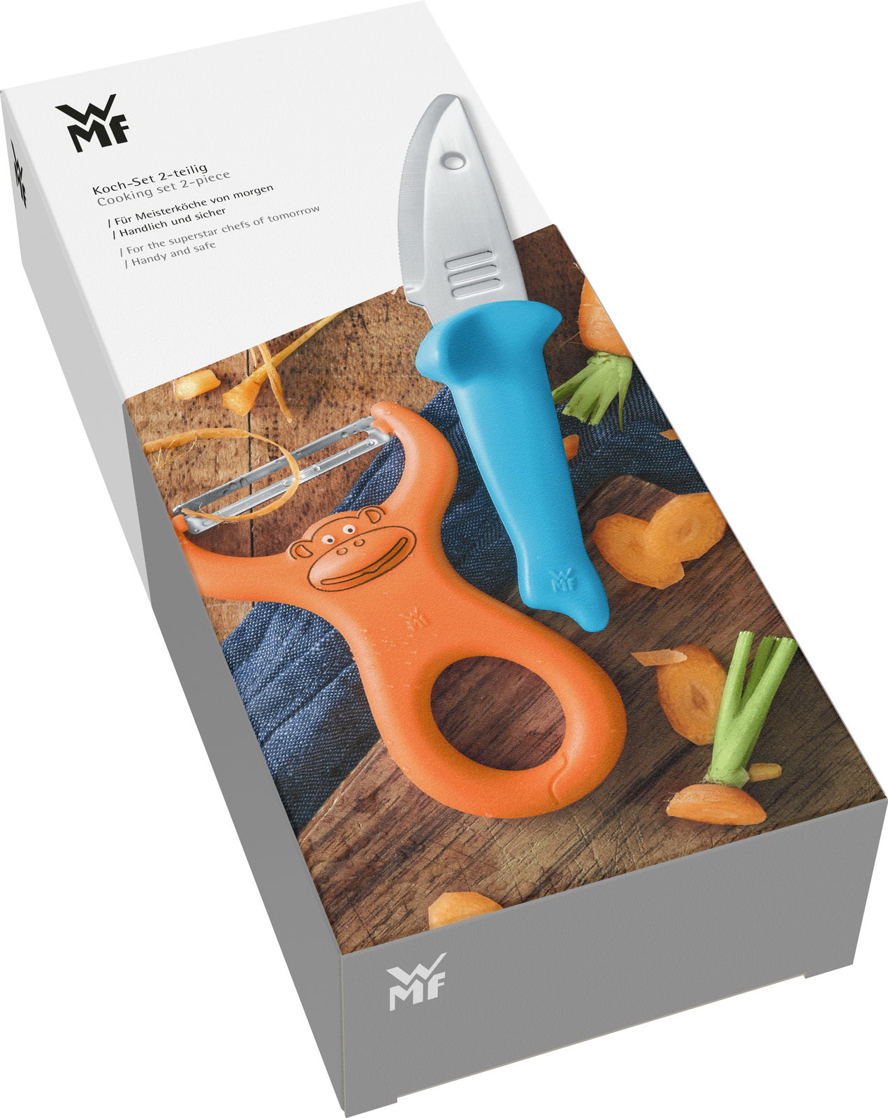 Koch-Set WILLY MIA FRED, bestehend aus einem blauen Messer und einem orangefarbenen Schäler mit Affenmotiv, auf einer Holzoberfläche mit geschnittenen Karotten, aus der Vogelperspektive.