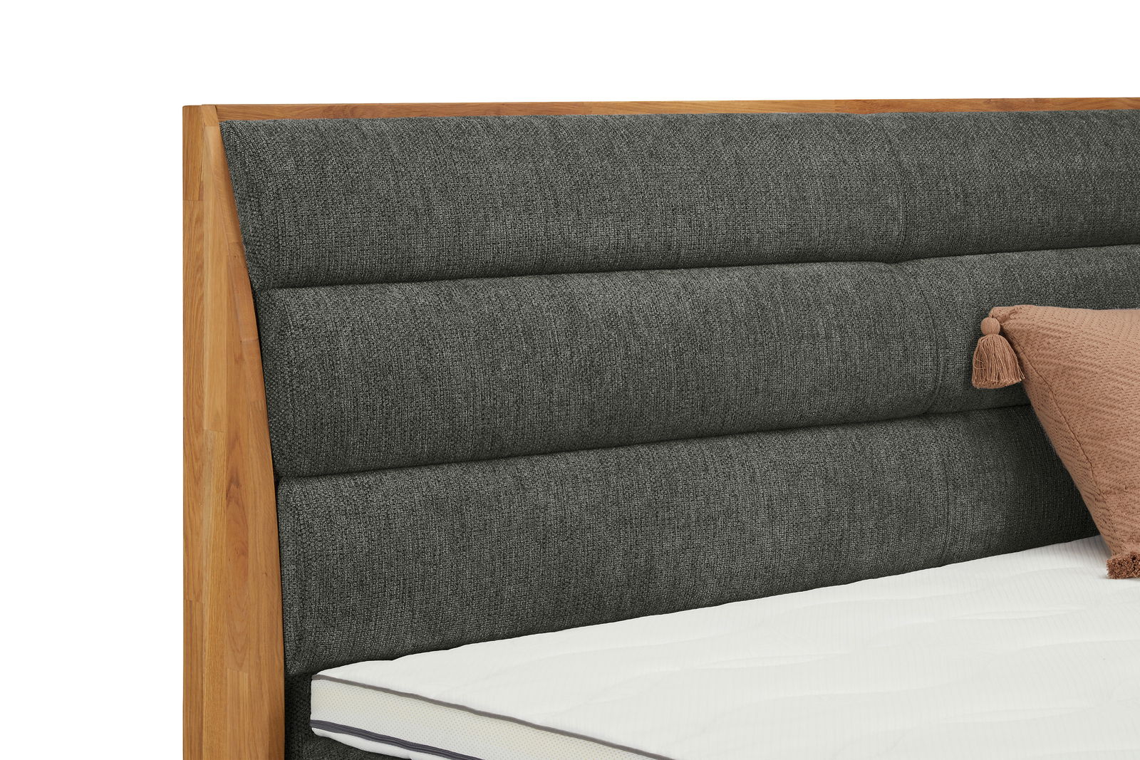 Nahaufnahme eines Boxspringbettes mit grauem, gepolstertem Kopfteil und Holzrahmen, seitliche Perspektive