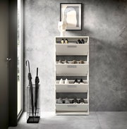 Moderner Schuhkipper mit vier Klappen, frontal fotografiert, in einem stilvollen Eingangsbereich mit grauer Wand und Regenschirmständer.