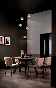 Moderne LED-Pendelleuchte in einem stilvollen Esszimmer, von unten betrachtet, mit mehreren hängenden Leuchten über einem runden Tisch mit eleganten Stühlen.