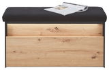 Garderobenbank mit schwarzer Polsterung und Holzfront, frontal fotografiert, mit einer Zeitschrift auf der Sitzfläche.