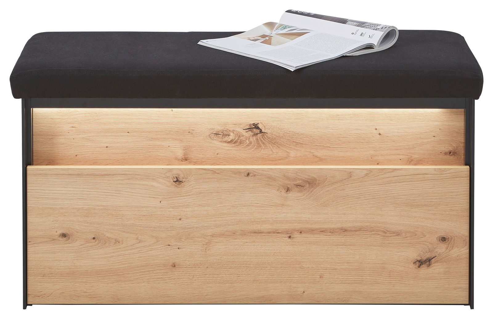 Garderobenbank mit schwarzer Polsterung und Holzfront, frontal fotografiert, mit einer Zeitschrift auf der Sitzfläche.