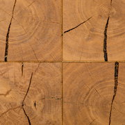 Draufsicht auf eine rustikale Holzoberfläche aus vier quadratischen Hirnholz-Blöcken mit sichtbaren Jahresringen und natürlichen Rissen in warmem Braunton