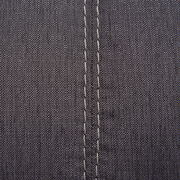 Nahaufnahme einer grauen Stoffoberfläche mit sichtbaren Nähten, perspektivisch von oben betrachtet.