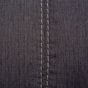 Nahaufnahme einer grauen Stoffoberfläche mit sichtbaren Nähten, perspektivisch von oben betrachtet.