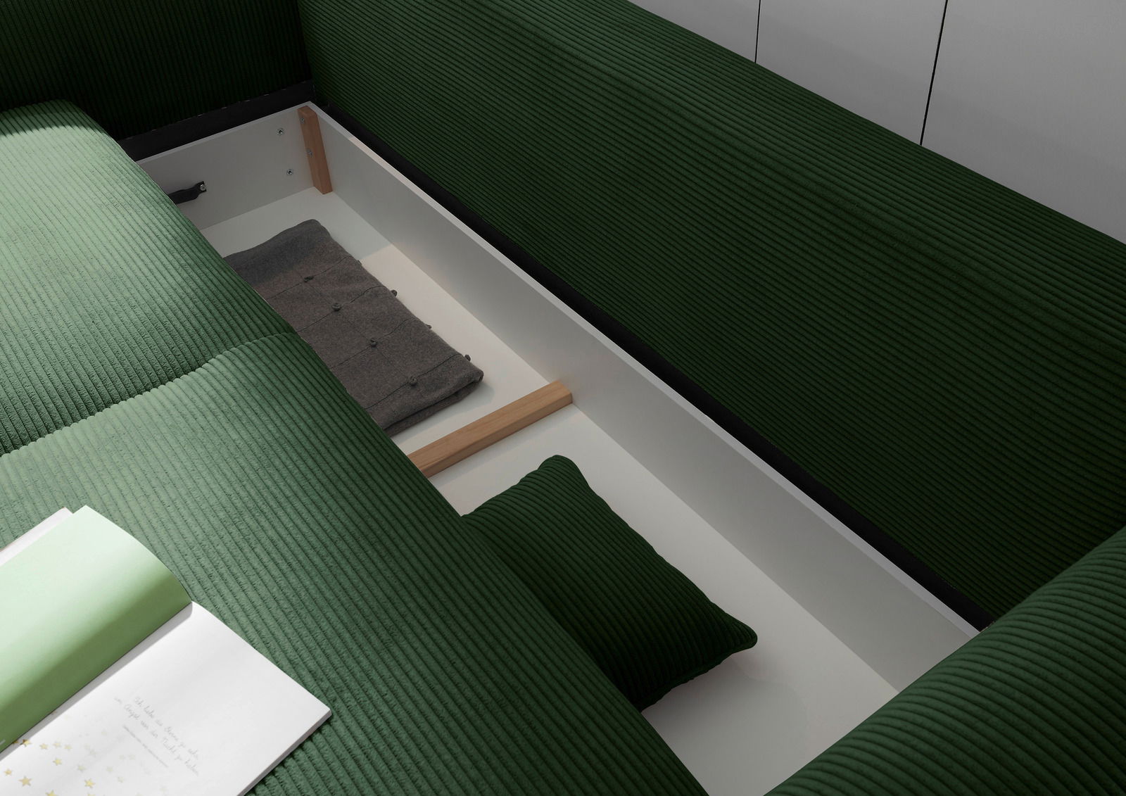 Grünes Funktionssofa mit geöffneter Stauraumfunktion, von oben betrachtet.