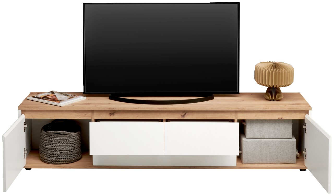 Vooraanzicht van een XL-tv-lowboard met houten afwerking, twee open lades en zijvakken met deurtjes. Versierd met een tv, een lamp en manden.