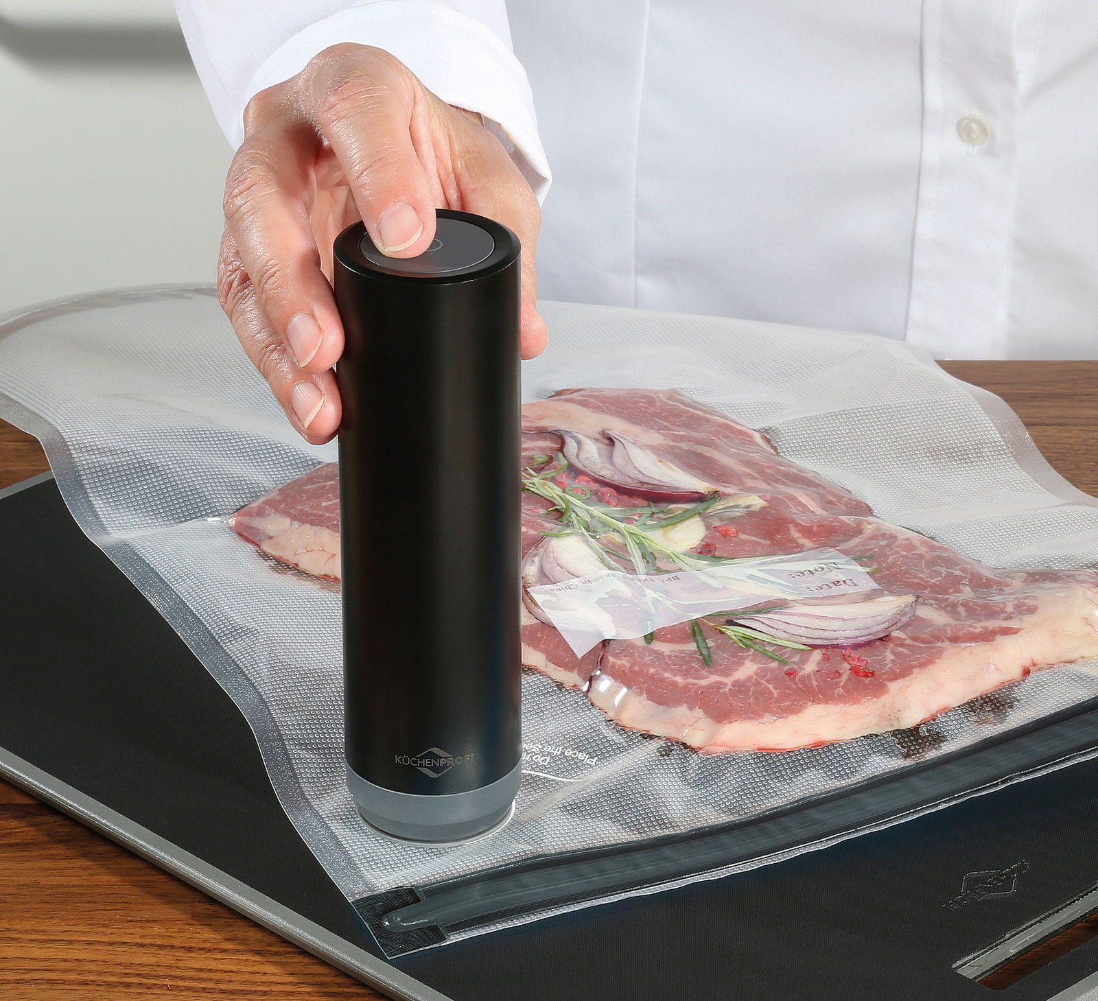 Vakuumier-Set EASYFRESH in Benutzung, seitliche Perspektive auf das Gerät, das Fleisch in einem Vakuumbeutel versiegelt.