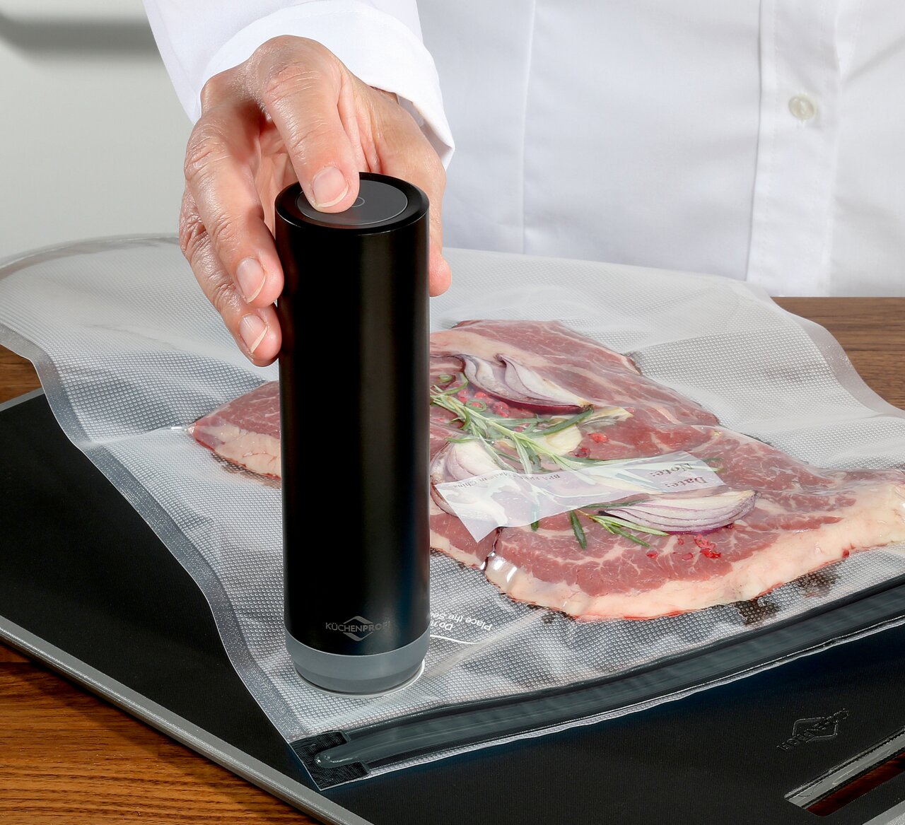 Vakuumier-Set EASYFRESH in Benutzung, seitliche Perspektive auf das Gerät, das Fleisch in einem Vakuumbeutel versiegelt.