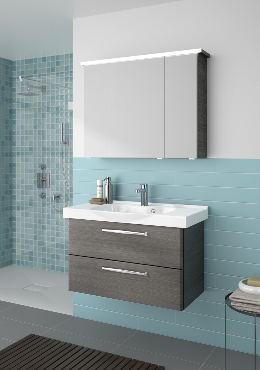 Pelipal Badblock 92cm TRENTINO Moderner Badblock mit Waschbecken und Unterschrank in Holzoptik, frontal betrachtet, vor einer Wand mit blauen Fliesen.