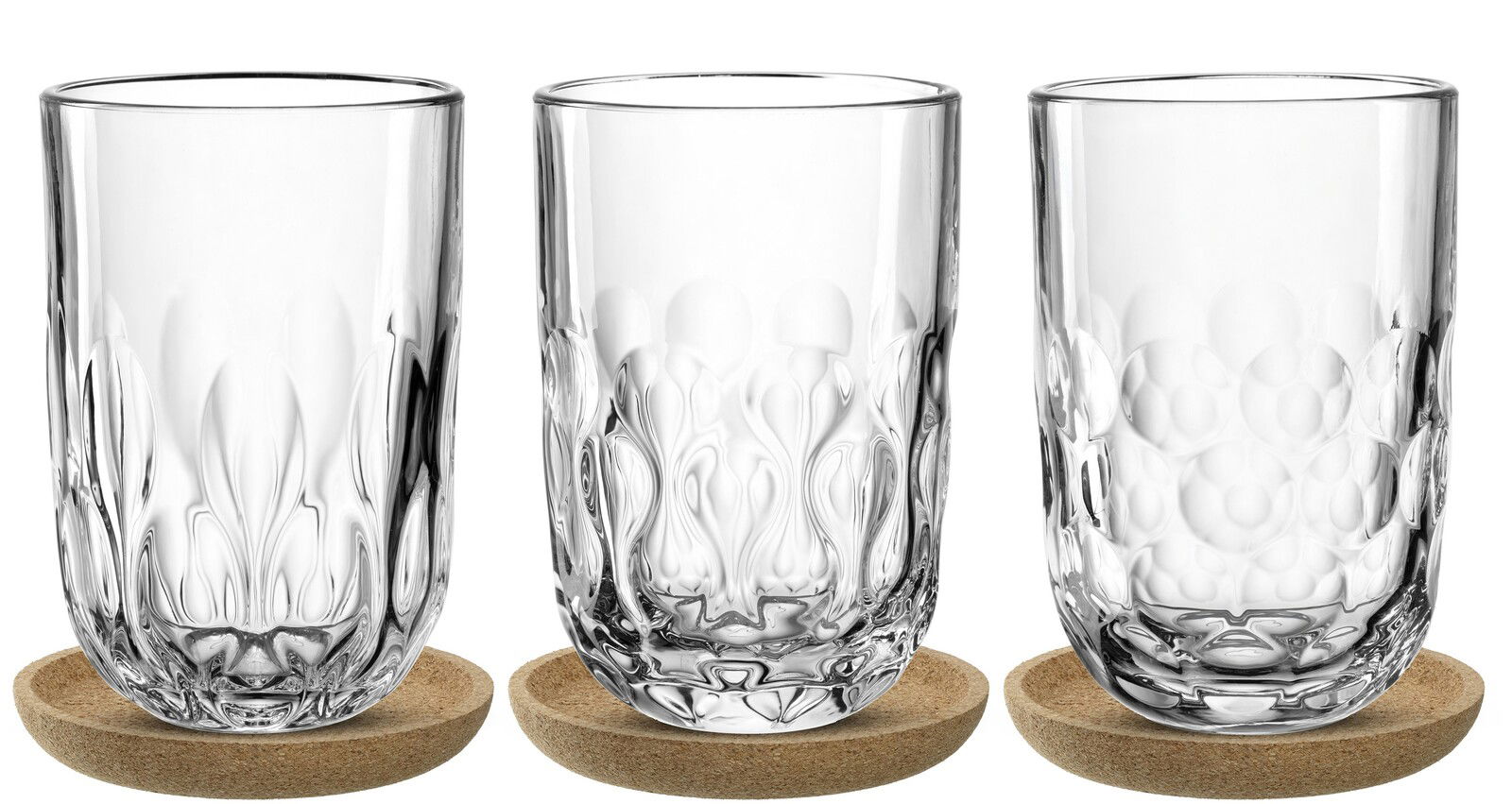 Drei Latte Macchiato-Gläser mit dekorativem Muster, auf runden Untersetzern, aus der Frontalperspektive fotografiert.