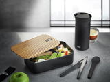 Lunchbox ENVIRO mit Bambusdeckel, gefüllt mit frischem Obst und Gemüse, auf einer Tischplatte. Perspektive von oben.