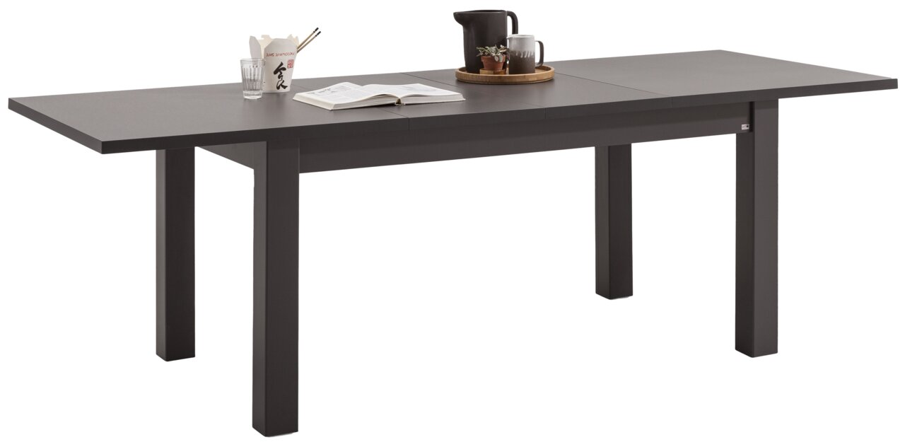 Moderner, ausziehbarer Esstisch in dunkler Farbe, seitliche Perspektive, dekoriert mit Geschirr und Pflanzen.