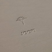 Nahaufnahme eines grauen runden Tabletts mit geprägtem Logo und Schriftzug 'JOOP!'