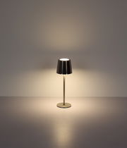 Moderne Tischleuchte mit metallischem Schirm, frontal beleuchtet auf neutralem Hintergrund