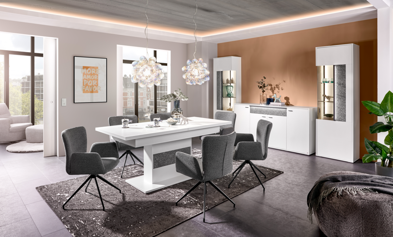 Set one by Musterring Funktions-Esstisch DELTONA Moderner Funktions-Esstisch in Weiß mit grauen Stühlen, umgeben von stilvoller Dekoration in einem hellen, eleganten Esszimmer. Perspektive: Frontalansicht.