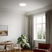 Moderne LED-Deckenleuchte in einem stilvollen Wohnzimmer, von unten betrachtet.