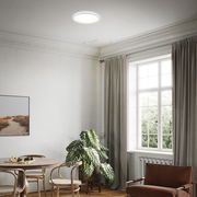 Moderne LED-Deckenleuchte in einem stilvollen Wohnzimmer, von unten betrachtet.