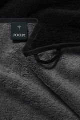 Nahaufnahme eines grauen Handtuchs mit schwarzem Rand und einem Joop-Label.