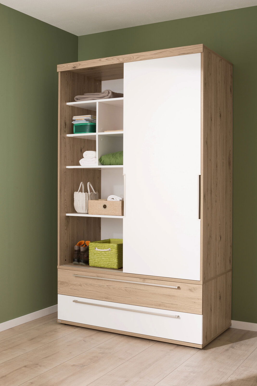 Schiebetürenschrank aus Holz mit weißer Tür, offene Regale mit grünen und weißen Körben, seitliche Perspektive