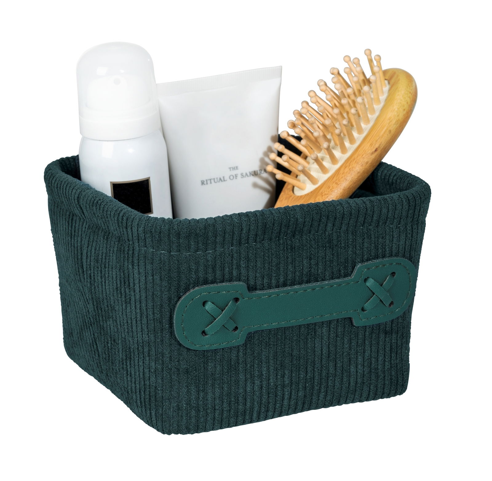 Dunkelgrüner, quadratischer Badkorb Anela mini mit Kord-Optik, gefüllt mit einer Haarbürste, einer Flasche und einer Tube, aus seitlicher Perspektive.
