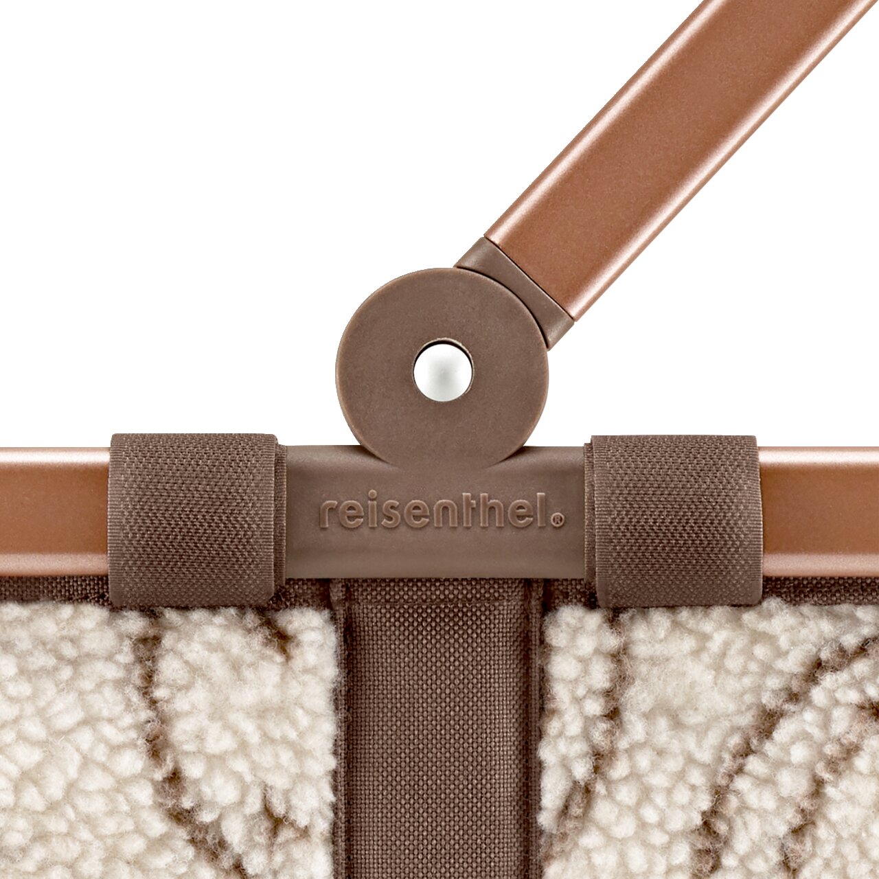 Detailaufnahme einer reisenthel Tasche/Korb in Braun-Beige mit Teddyfleece-Optik, braunem Griff und geprägtem reisenthel-Logo, frontale Nahansicht