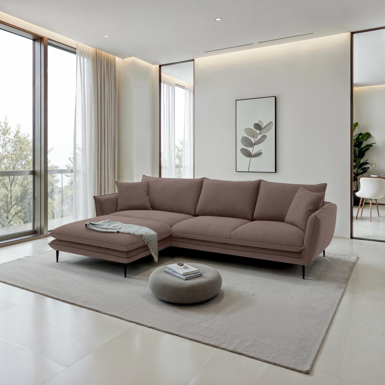 Modernes L-förmiges Ecksofa in Taupe mit Chaiselongue links, schlanken schwarzen Metallfüßen und passenden Kissen, in hellem Wohnzimmer auf Teppich – Frontansicht in leichter Schrägperspektive.