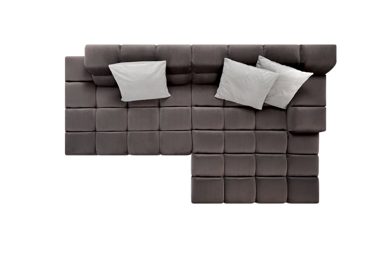 Draufsicht auf eine moderne Longchairkombination in dunklem Stoff mit drei hellen Kissen.