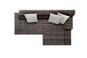 Bovenaanzicht van een moderne longchair-set in donkere stof met drie lichte kussens.