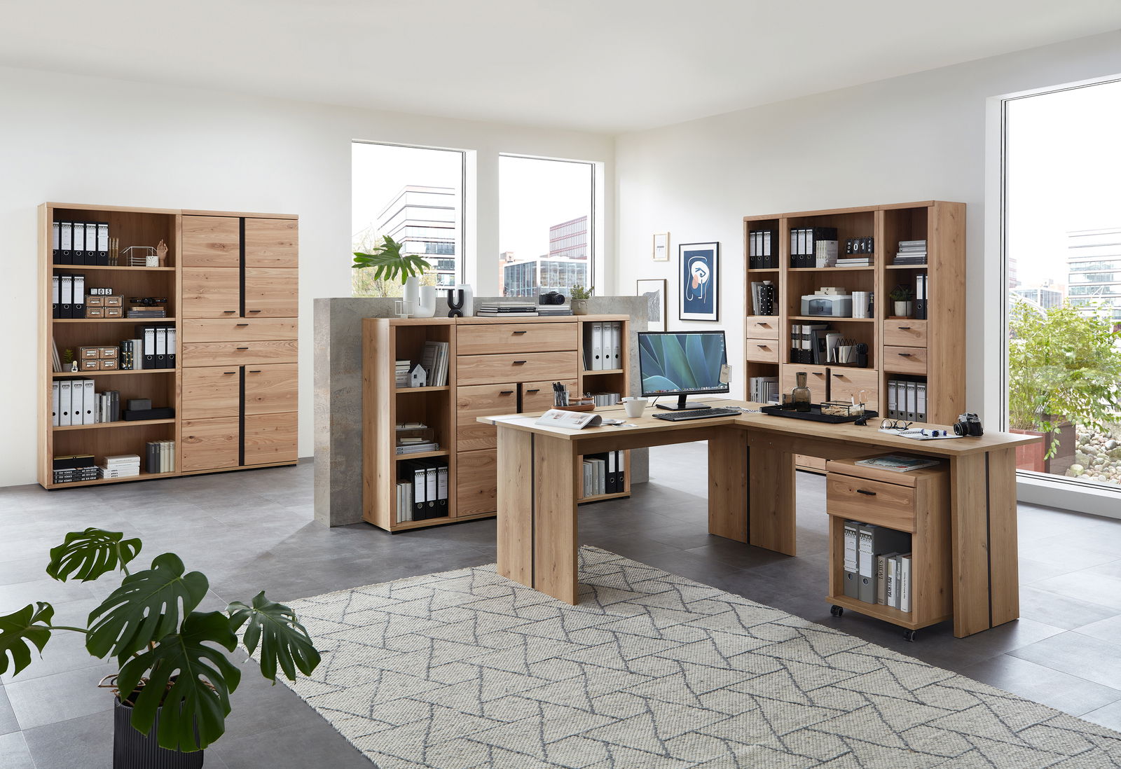 Moderne Büromöbel in einem hellen Raum mit großen Fenstern, bestehend aus Aktenschränken, Regalen und einem Eckschreibtisch aus Holz. Perspektive: Frontalansicht.