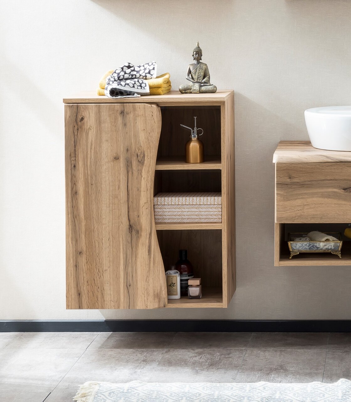 Moderner Unterschrank aus Holz mit offener Tür, zeigt Regale mit Handtüchern und Dekorationen, seitliche Perspektive.