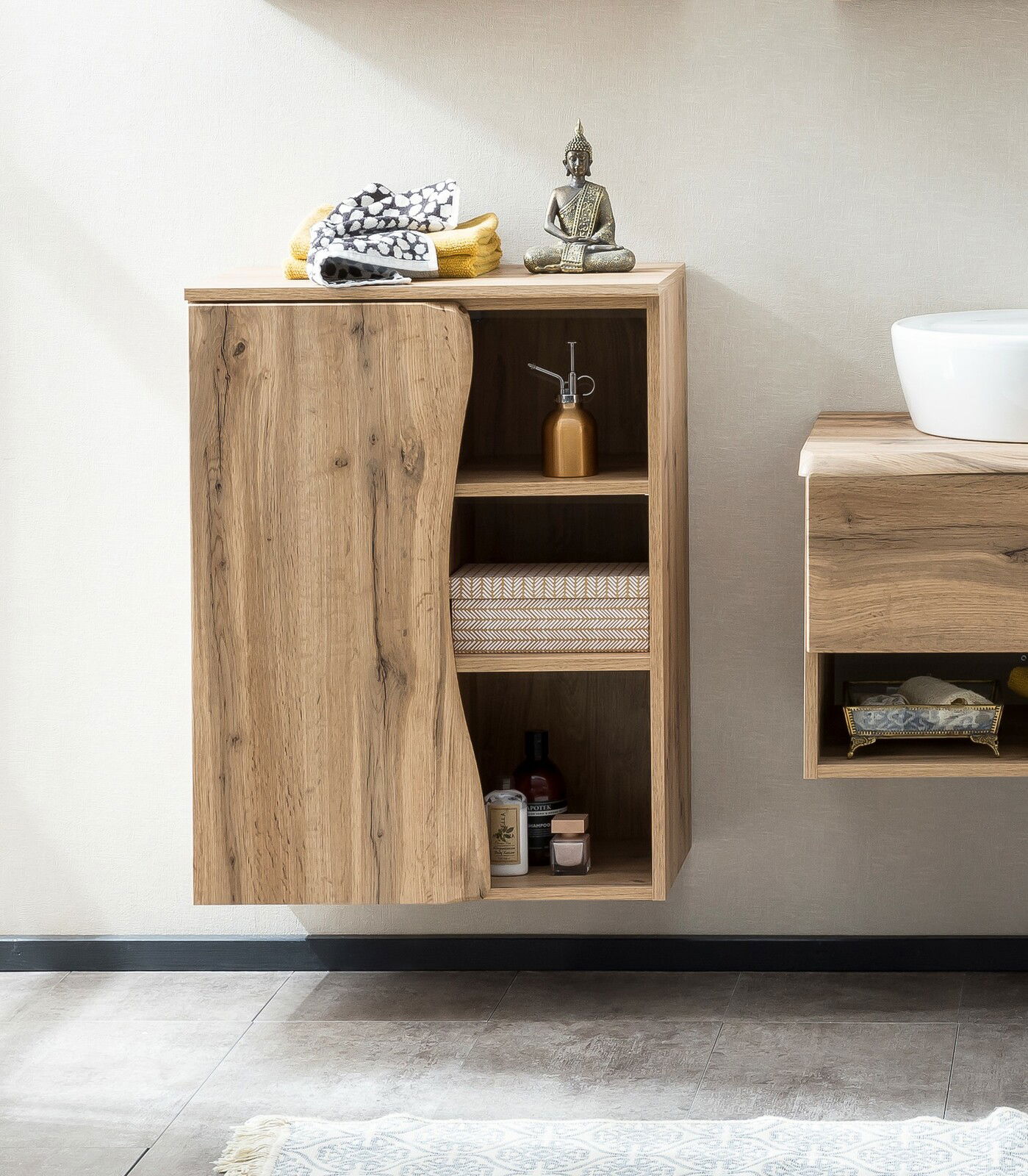 Moderner Unterschrank aus Holz mit offener Tür, zeigt Regale mit Handtüchern und Dekorationen, seitliche Perspektive.