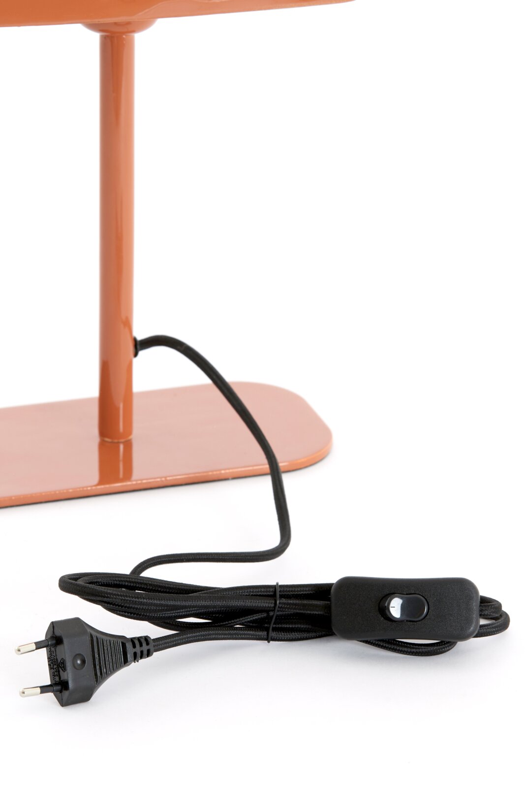 Nahaufnahme einer Tischleuchte in orange mit schwarzem Kabel und Schalter, seitliche Perspektive.