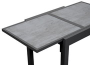 Moderne tuintafel met een grijs oppervlak in steenlook, in perspectief van bovenaf gezien.