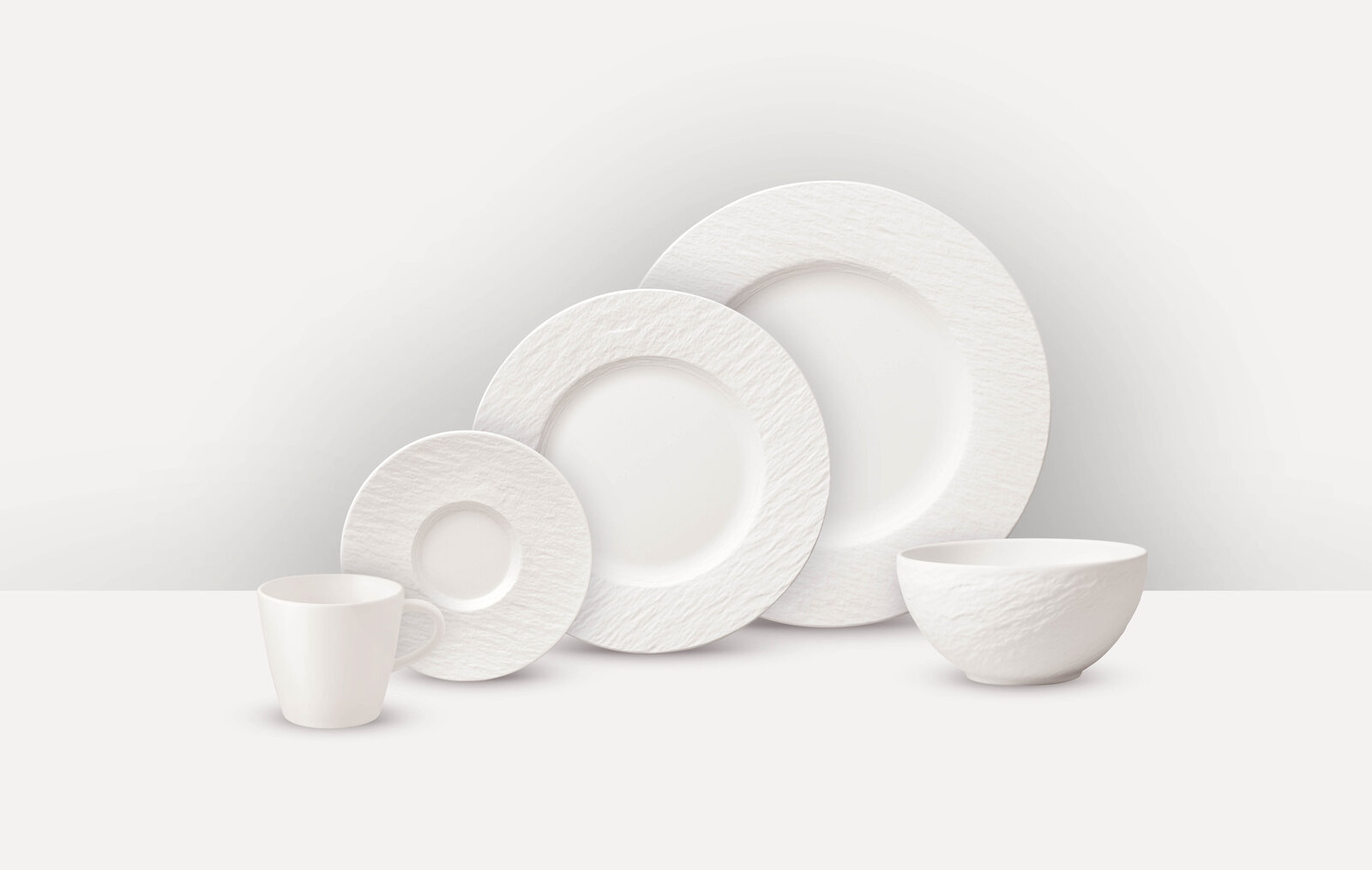 Komiservice 20-tlg. in seitlicher Perspektive: Tasse, Untertasse, Teller und Schüssel in schlichtem Weiß.