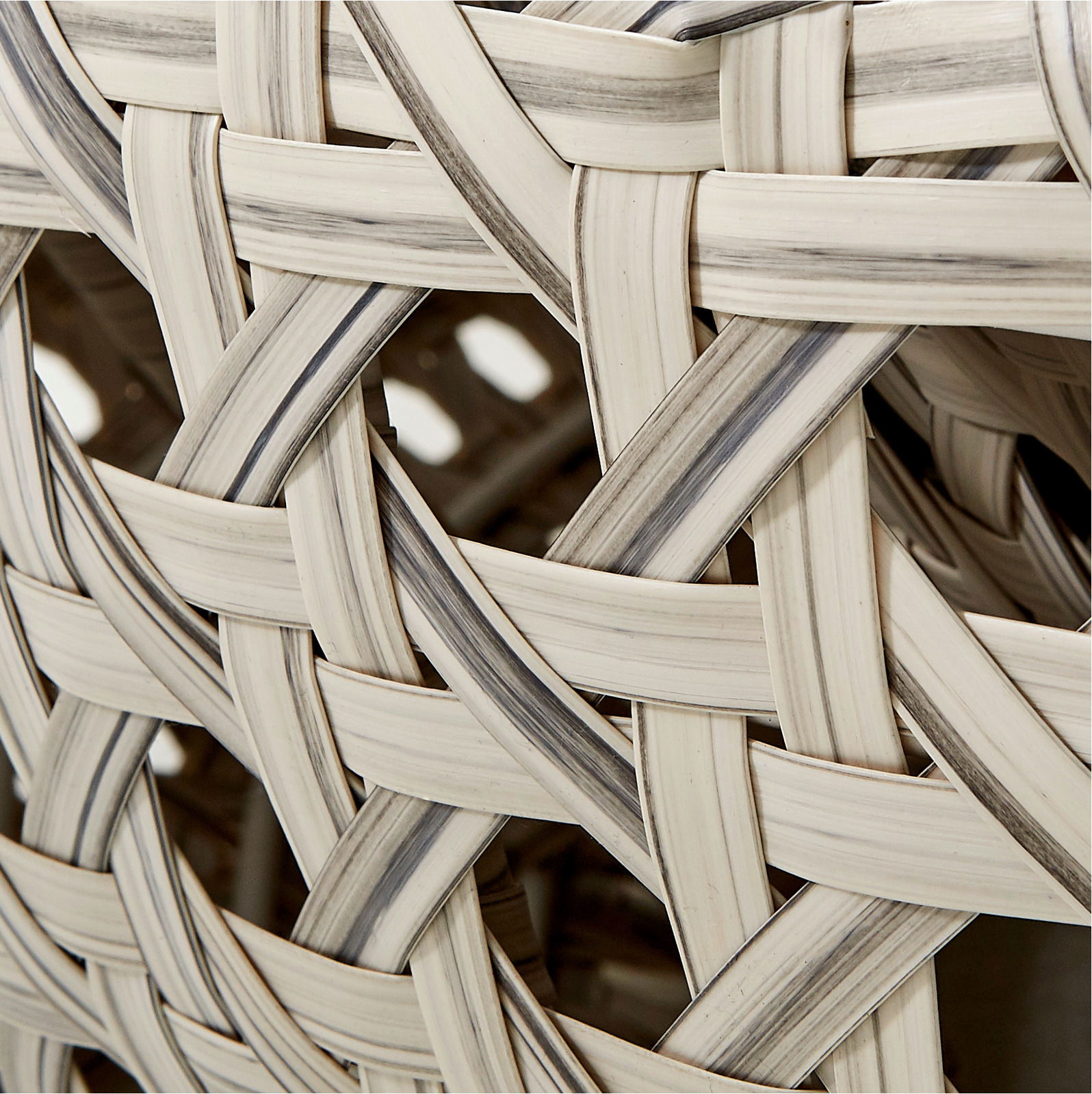 Nahaufnahme eines geflochtenen Musters aus hellen und dunklen Streifen, perspektivisch von der Seite aufgenommen.